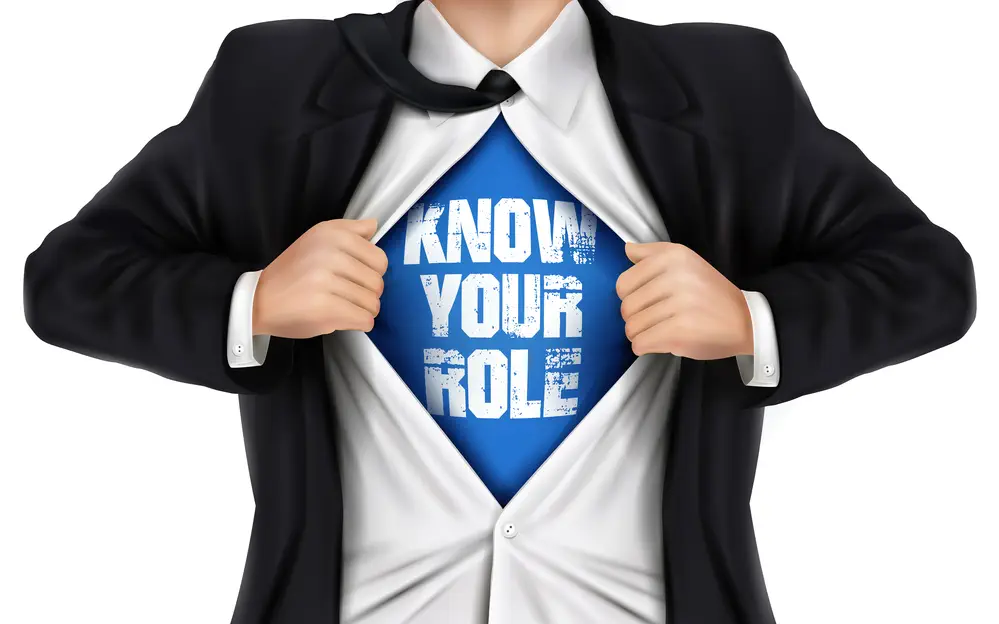 businessman showing Know your role words underneath his shirt over white background