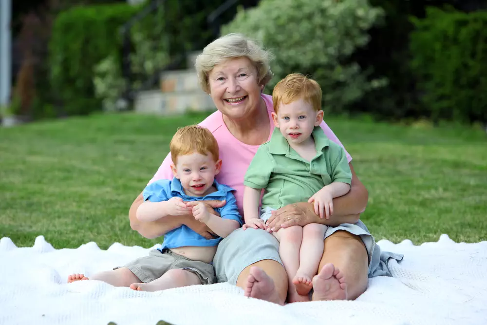 Happy grandmother holding twin boys