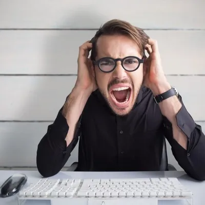 Minimum Viable Development For Founding CEOs Businessman yelling with his hands on face against painted blue wooden planks