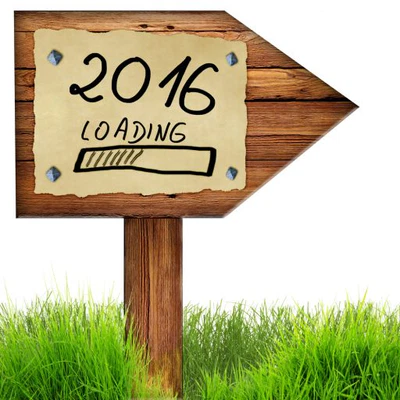Wood arrow sign with 2016 loading handwritten on old page of paper nailed to planks, green grass around, isolated on a white background.