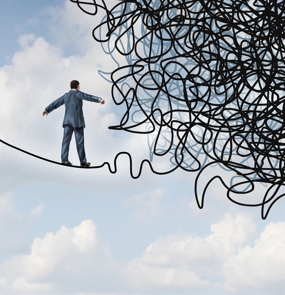 Risk confusion business concept with a businessman on a high wire tight rope walking towards a tangled mess as a metaphor and symbol of overcoming adversity in strategy and finding solutions through skilled leadership facing difficult obstacles.